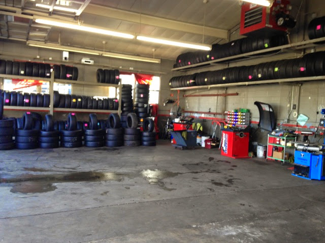 Racks of tires stocked along the wall inside the Portland Tire Shop bay