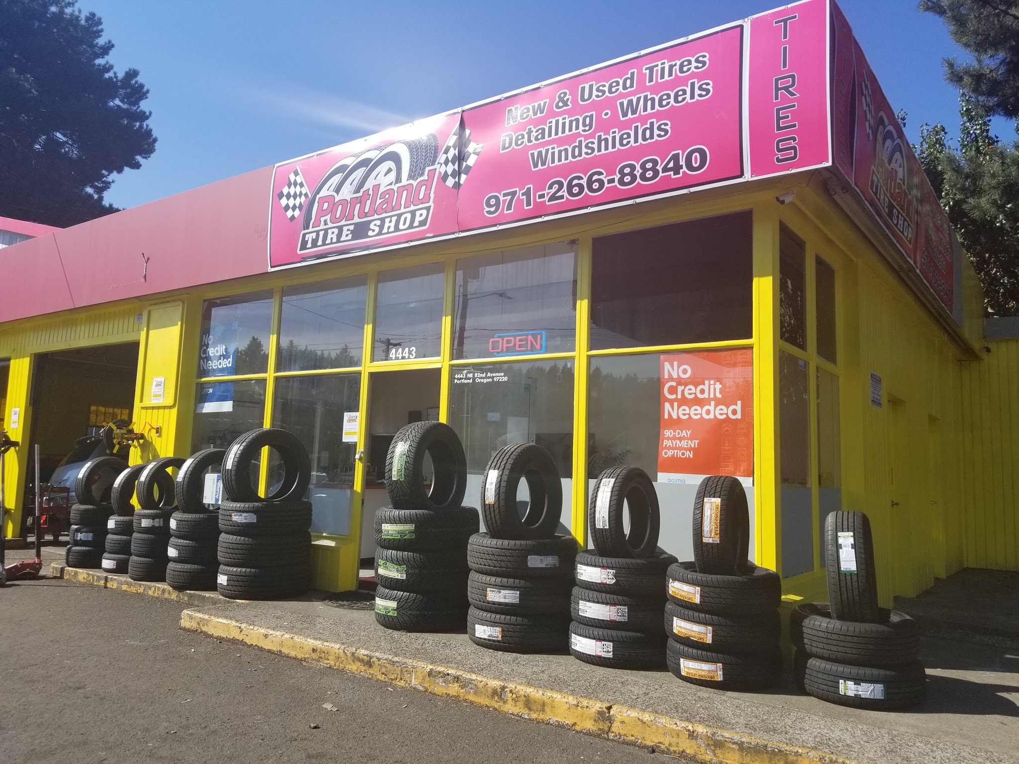 Tires lined up along the front of the Portland Tire Shop building on NE 82nd Avenue